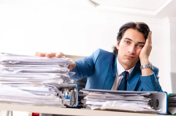 Joven empleado ocupado guapo sentado en la oficina — Foto de Stock