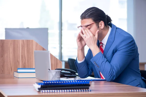 Jovem empresário bonito sentado no escritório — Fotografia de Stock