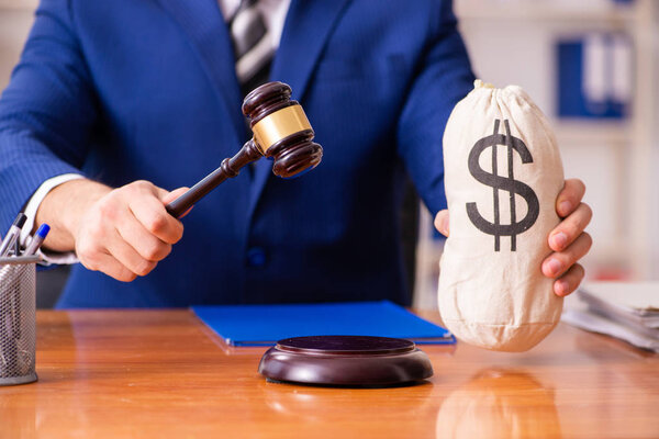 Young male judge sitting in courtroom