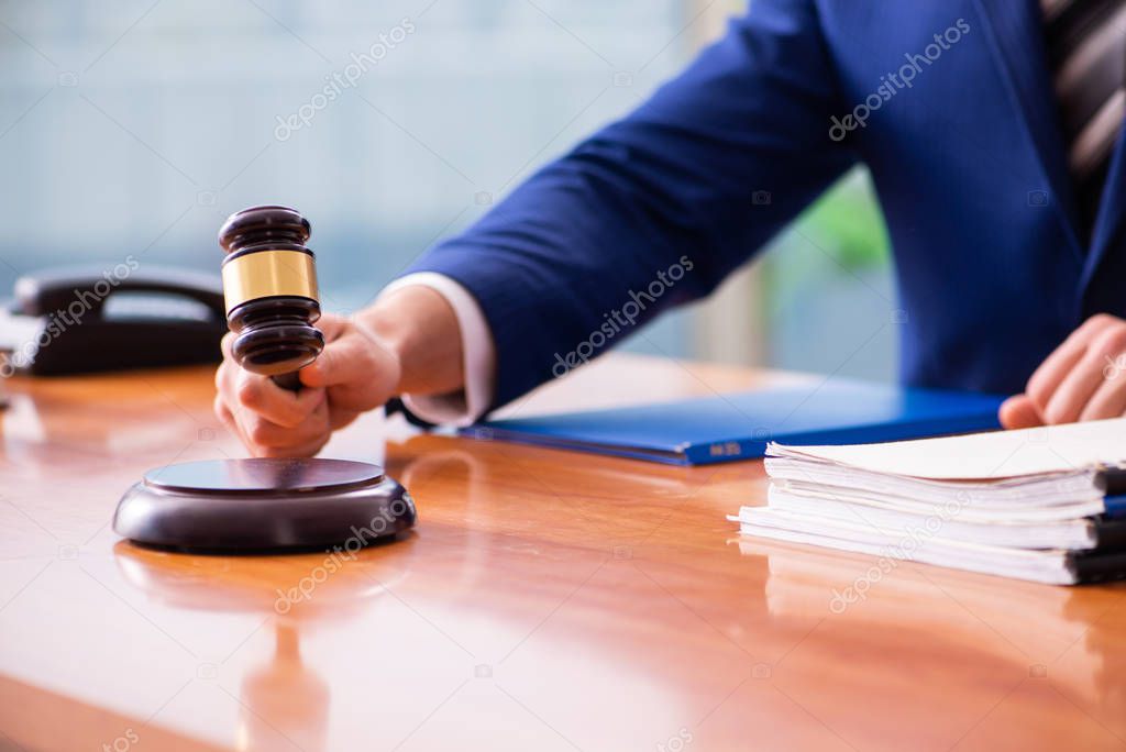 Young male judge sitting in courtroom