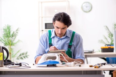 Delikanlı servis merkezinde demir onarıyor.