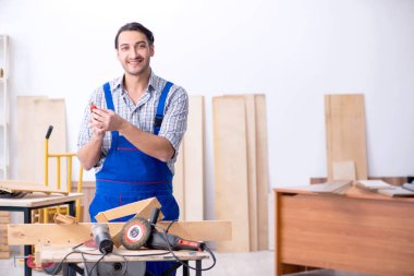 Genç erkek marangoz içeride çalışıyor.