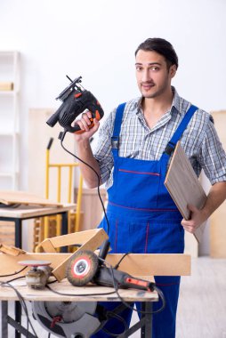 Genç erkek marangoz içeride çalışıyor.