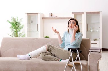 Araba kazasından sonra evde acı çeken genç bir kadın.