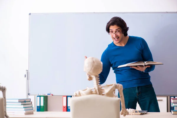 Profesor masculino y estudiante de esqueleto en el aula — Foto de Stock