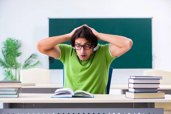 Joven estudiante masculino frente al tablero verde —  Fotos de Stock