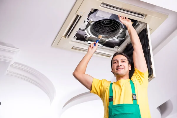 Joven reparador reparación de la unidad de aire acondicionado del techo — Foto de Stock