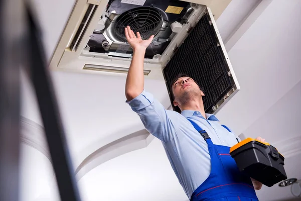 Junger Reparateur repariert Klimaanlage an der Decke — Stockfoto