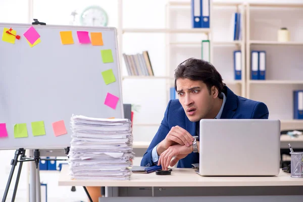 Joven empleado masculino infeliz con el trabajo excesivo —  Fotos de Stock