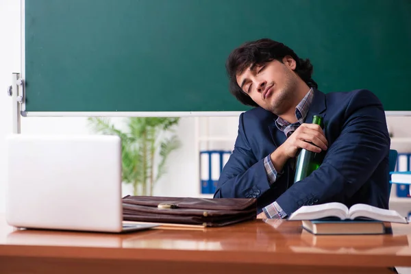 Male teacher drinking in the classroom — Stock Photo, Image