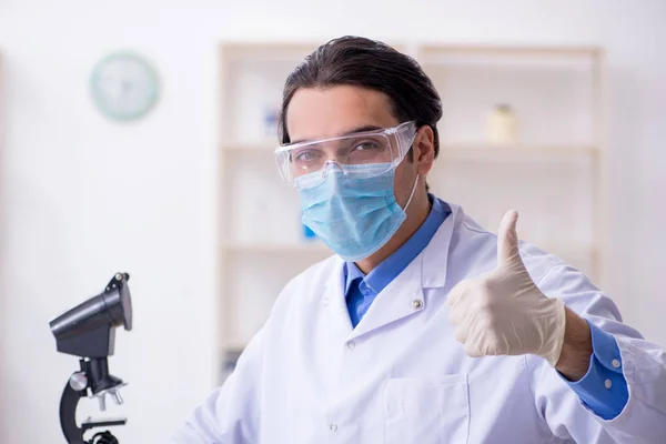 Jovem químico do sexo masculino experimentando em laboratório — Fotografia de Stock