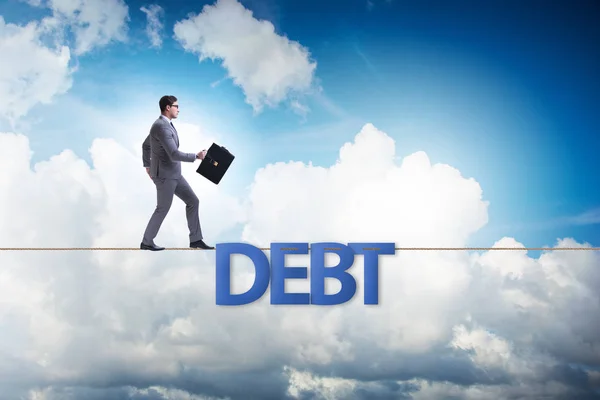 Dług i kredyt koncepcja z biznesmen chodzenie na ciasnej liny — Zdjęcie stockowe