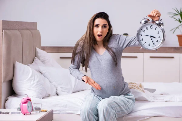 Junge schwangere Frau im Schlafzimmer — Stockfoto