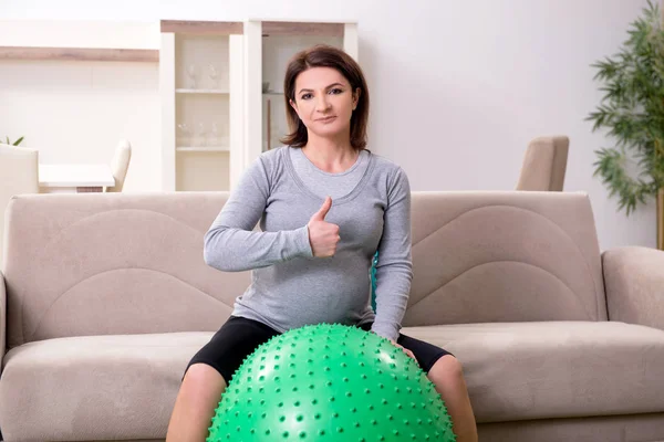 У віці вагітна жінка робить вправи вдома — стокове фото