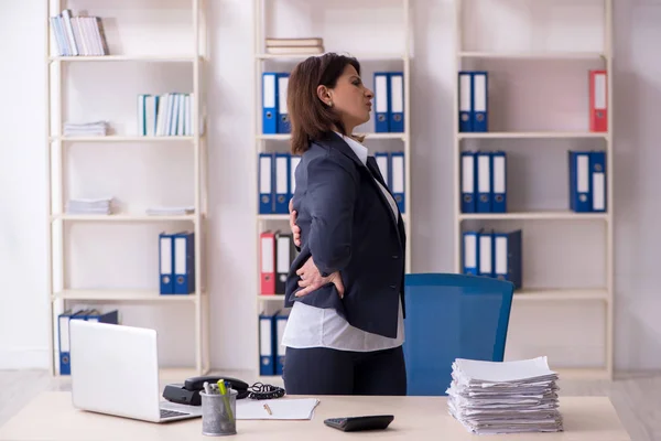 Medelålders kvinnlig arbetstagare som lider på kontoret — Stockfoto