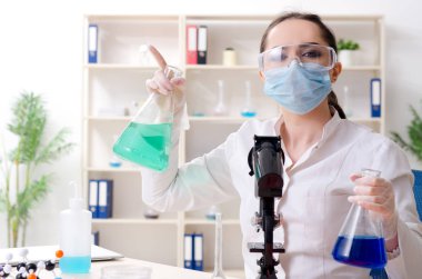 Laboratuvarda çalışan genç bir kadın kimyager.