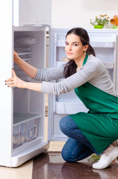 Young woman cleaning fridge in hygiene concept — Stock Photo, Image