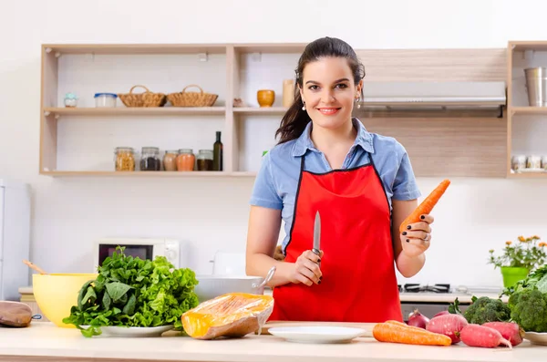 Mujer joven con verduras en la cocina — Foto de Stock