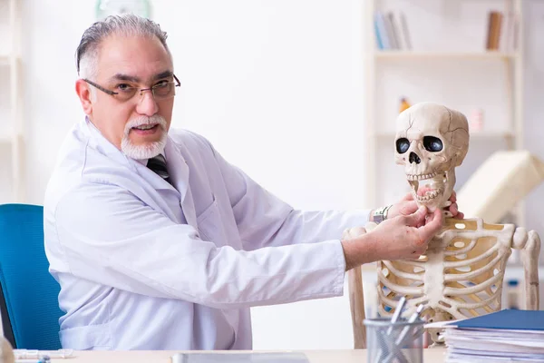 Médico do sexo masculino envelhecido com esqueleto — Fotografia de Stock