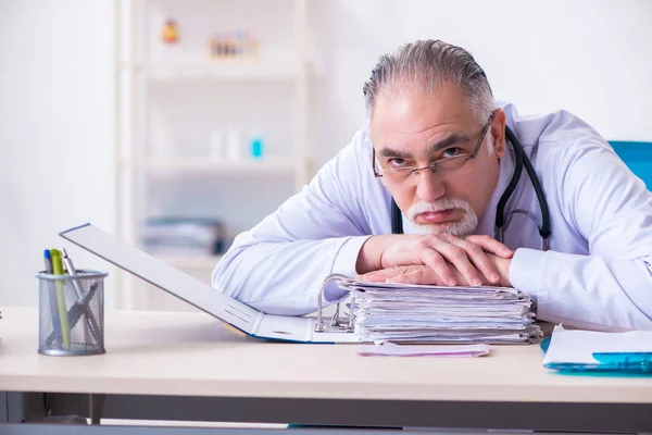 Gammal manlig läkare som arbetar på kliniken — Stockfoto