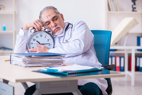 Klinikte çalışan yaşlı erkek doktor. — Stok fotoğraf