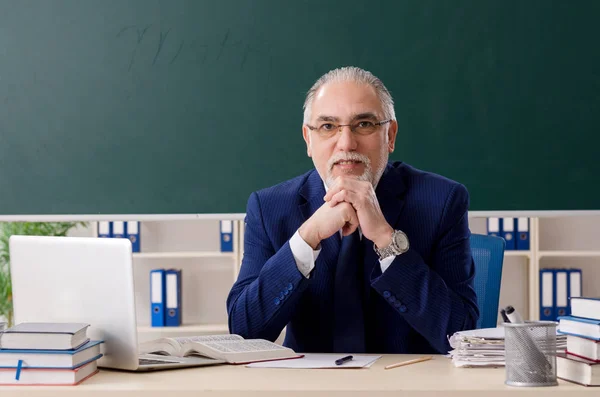 Leeftijd mannelijke leraar in de voorkant van schoolbord — Stockfoto