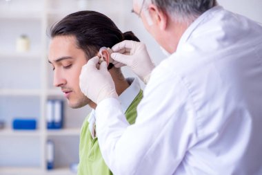 İşitme sorunu olan erkek hasta doktor otorhinolaryng 'i ziyaret ediyor.