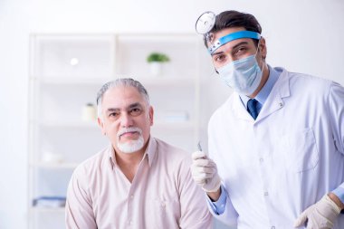 Erkek hasta doktor otolaryngologu ziyaret ediyor.