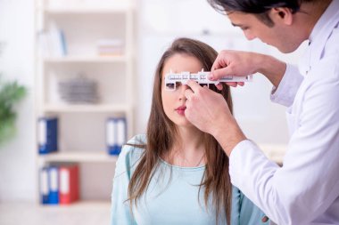 Genç bir kadın, erkek doktoru ziyaret ediyor.