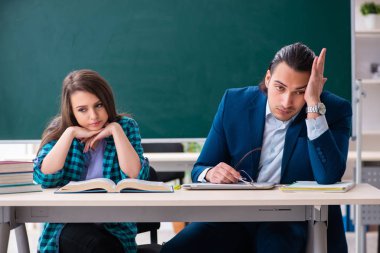 Sınıftaki genç, yakışıklı öğretmen ve bayan öğrenci.