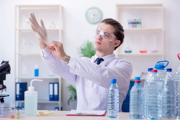 젊은 남성 화학자가 실험실에서 실험을 하는 모습 — 스톡 사진