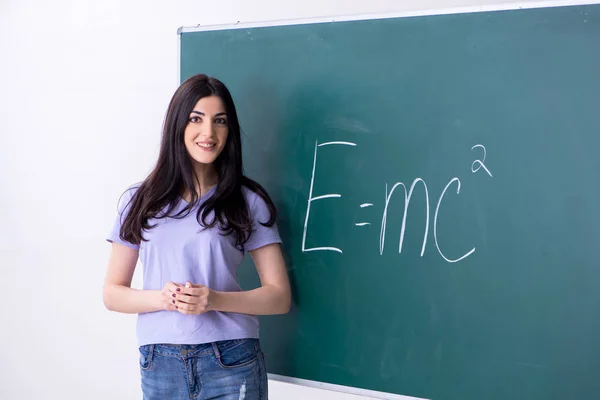 Fiatal tanárnő tanuló a zöld tábla előtt — Stock Fotó