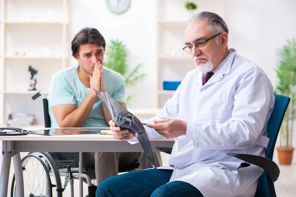 Mannelijke patiënt in rolstoel op bezoek bij oude arts — Stockfoto