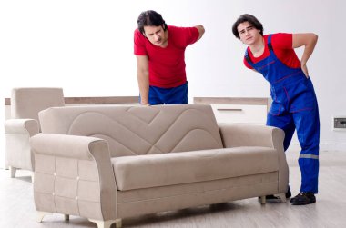 İki genç müteahhit kişisel eşyalarını taşıyor.