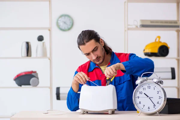 Jovem empreiteiro reparando torradeira na oficina — Fotografia de Stock