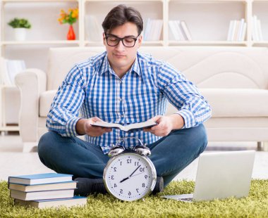 Genç yakışıklı adam evde yerde oturuyor.