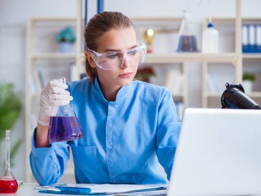 Bir laboratuarda deney yapan kadın bir bilim adamı.