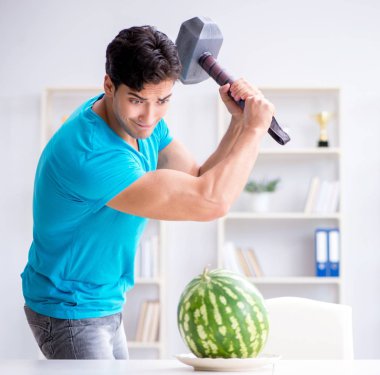 Evde karpuz yiyen bir adam.