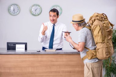 Otel resepsiyonunda sırt çantalı.