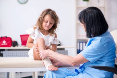 Küçük kız yaşlı kadın doktoru ziyaret ediyor.