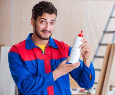 Yooung marangoz boyayla uğraşıyor.