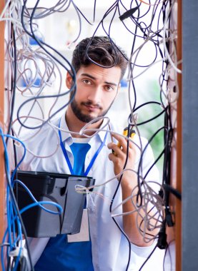 Elektrik teknisyeni tamir konseptinde kabloları çözmeye çalışıyor.