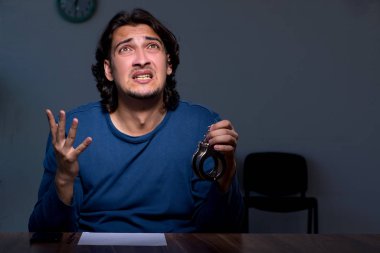 Genç mahkum karanlık odada oturuyor.