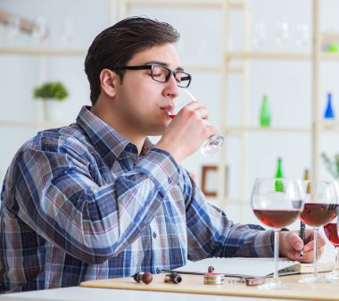 Profesyonel şarap garsonu kırmızı şarap tadıyor.