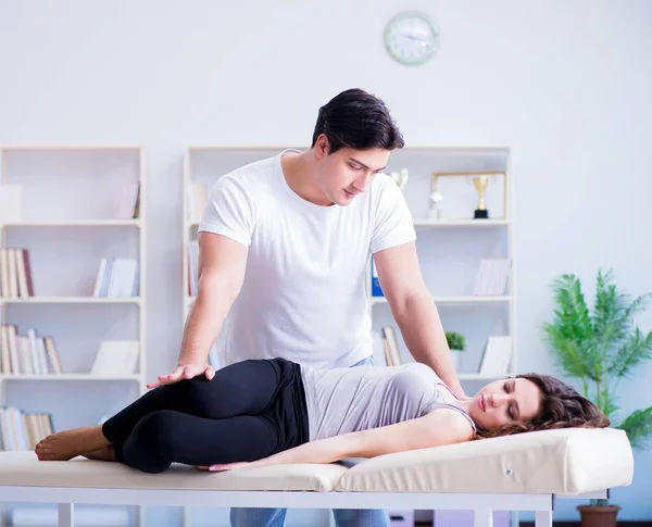 Jovem médico quiroprático massageando mulher paciente — Fotografia de Stock