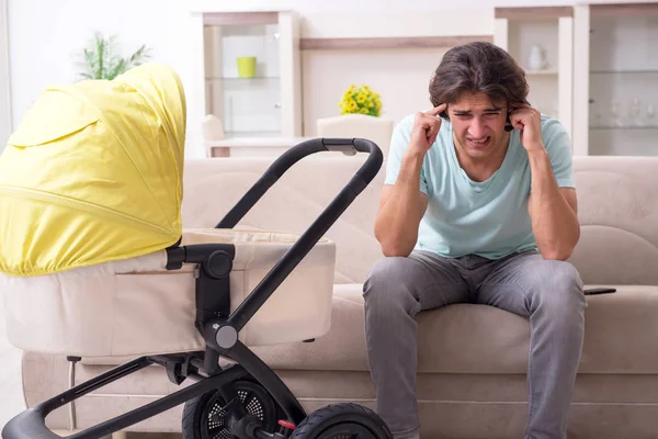 Junger Mann kümmert sich um Baby im Kinderwagen — Stockfoto