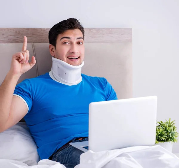 De jongeman met nekletsel in het bed — Stockfoto
