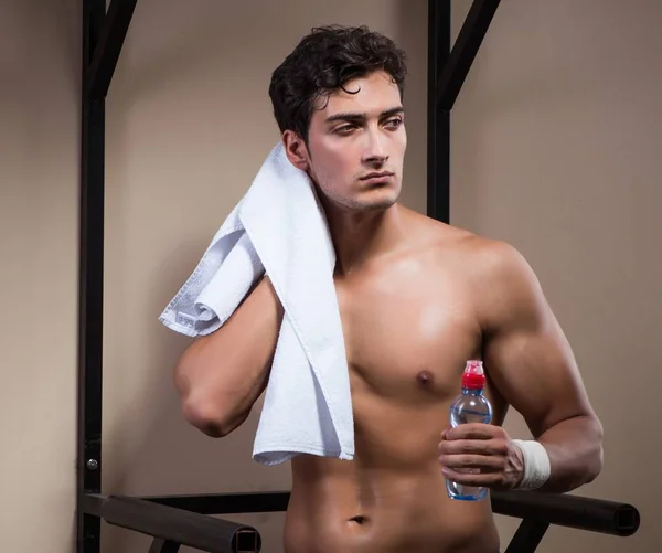 Žíznivý muž pitná voda ve sportovní tělocvičně — Stock fotografie