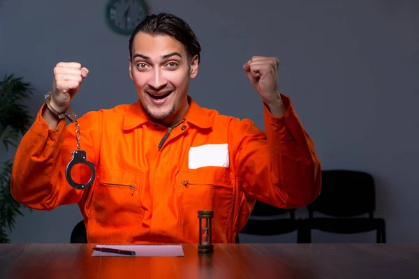 Young convict man sitting in dark room — Stock Photo, Image