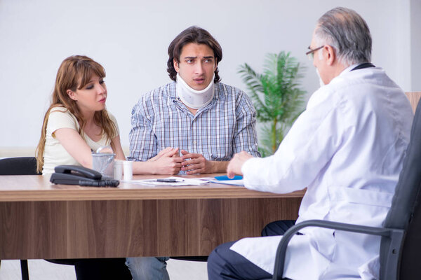 Молодая пара, посещающая пожилого врача